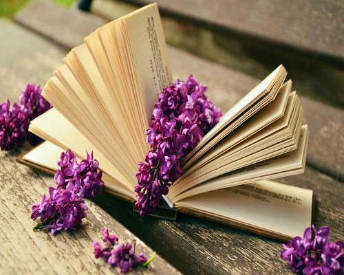 A glass of water next to an open book